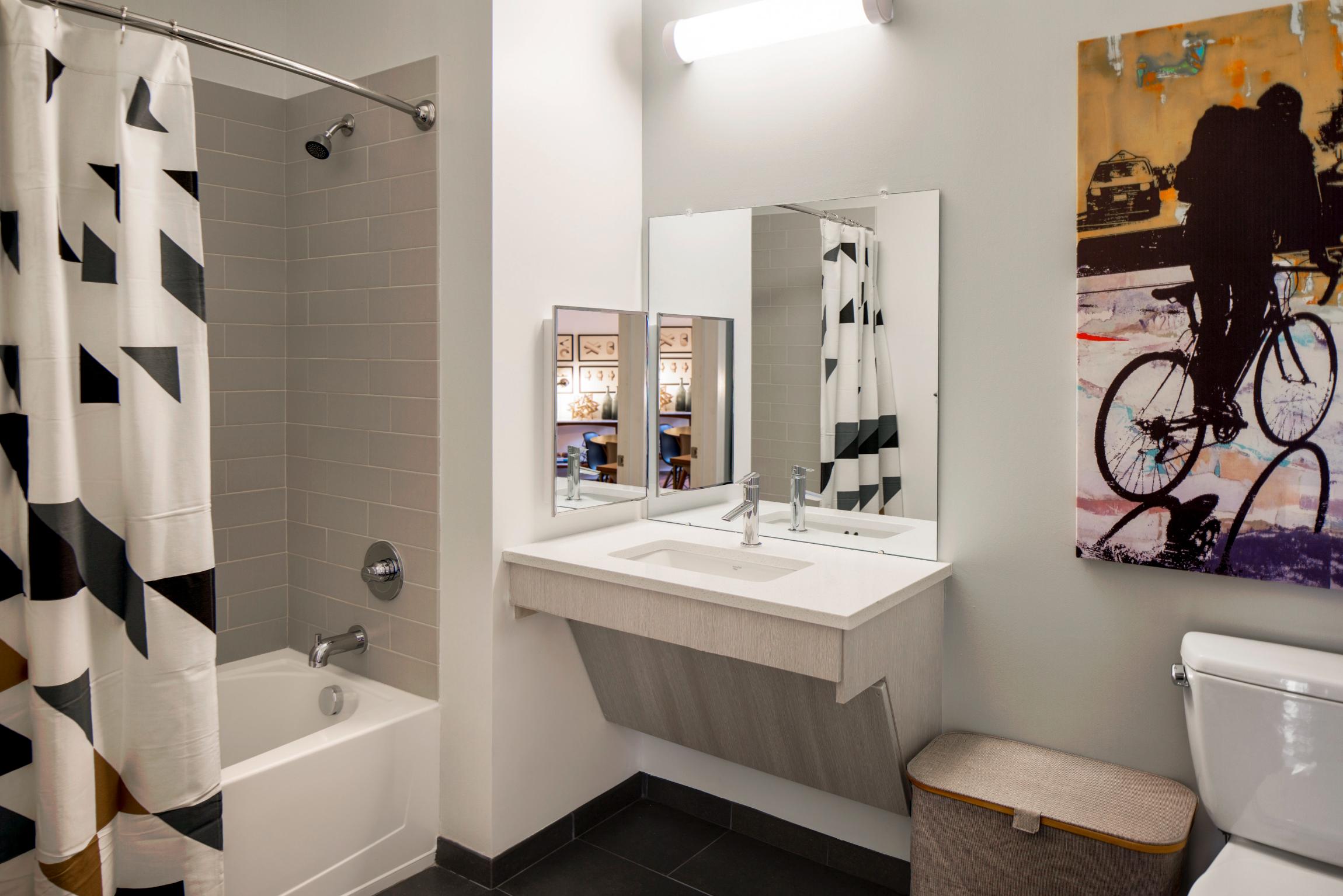 Sleek bathroom with a stylish tub and double mirrors over a minimalist sink
