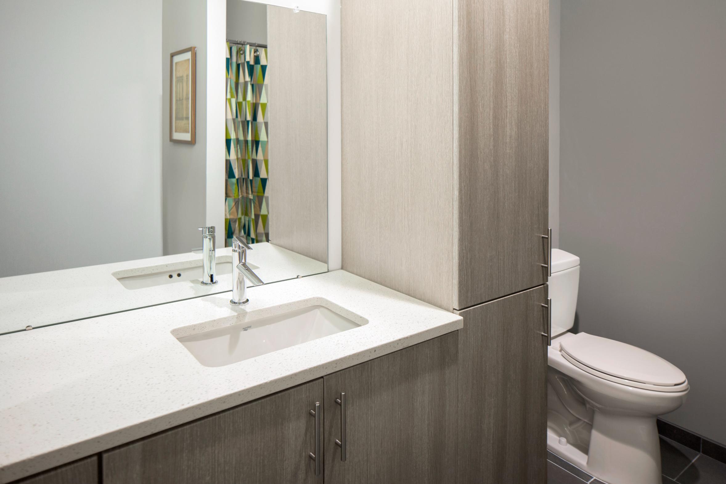 Contemporary bathroom with a tall vanity, sink, and side cabinetry for ample storage